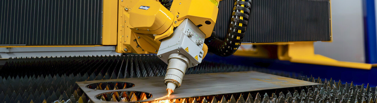 Präzisionsblechbearbeitung mit Lasertechnologie Industrieller Laserprozess: Gelber Laserkopf schneidet ein Metallblech.